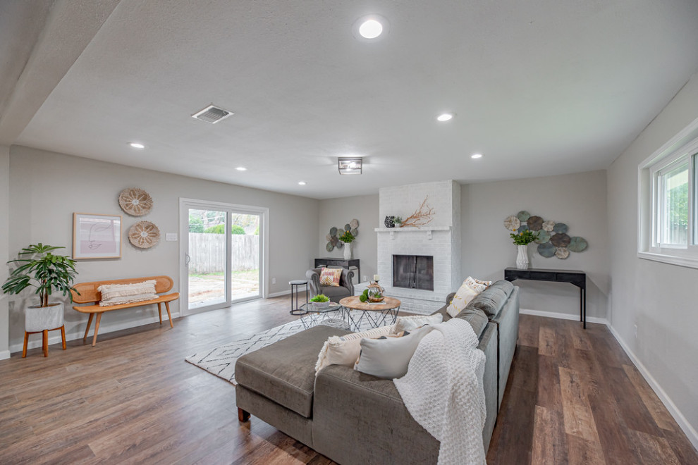 Example of a mid-sized transitional formal and open concept vinyl floor living room design in Houston with gray walls, a standard fireplace and a brick fireplace