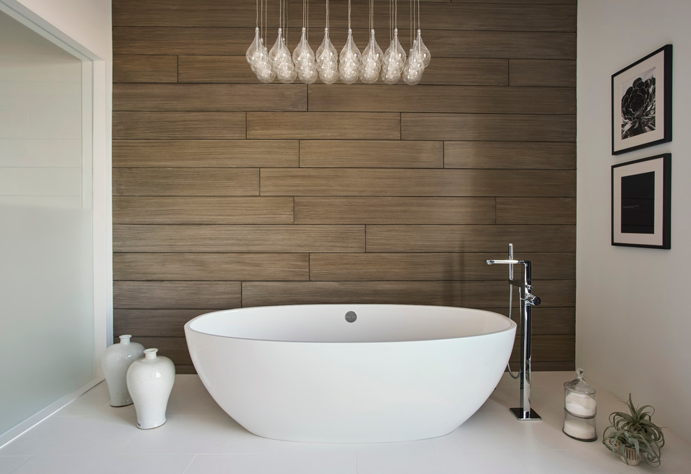 Design ideas for a large contemporary master bathroom in Chicago with flat-panel cabinets, medium wood cabinets, white tile, a freestanding tub, stone slab, white walls, porcelain floors and an integrated sink.
