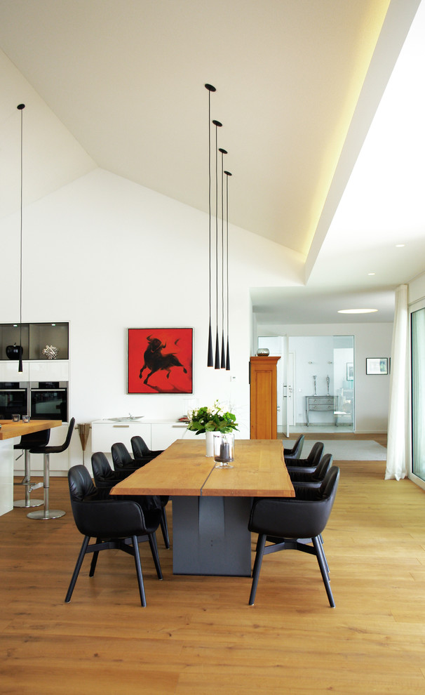 Large contemporary open plan dining in Other with white walls and light hardwood floors.
