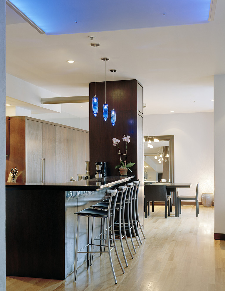 This is an example of a contemporary eat-in kitchen in Boston with granite benchtops, flat-panel cabinets and medium wood cabinets.