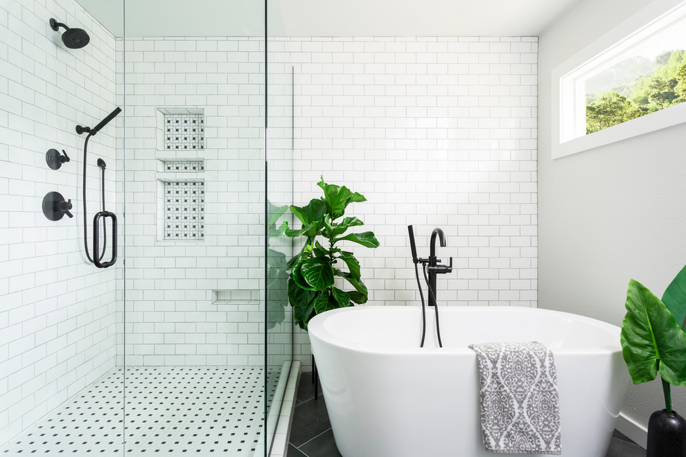 Photo of a transitional master bathroom in Denver with a freestanding tub, a corner shower, white tile, subway tile, white walls and black floor.