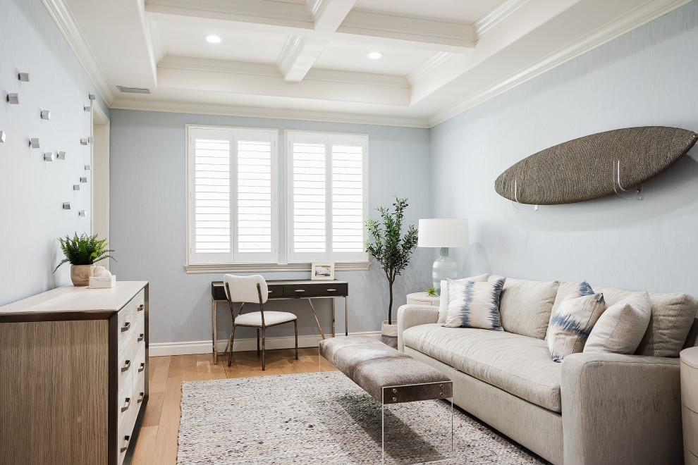This is an example of a medium sized beach style guest bedroom in Los Angeles with blue walls, light hardwood flooring, beige floors, a vaulted ceiling and wallpapered walls.