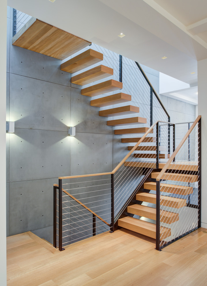 Staircase - mid-sized modern wooden floating open, cable railing and wall paneling staircase idea in San Francisco