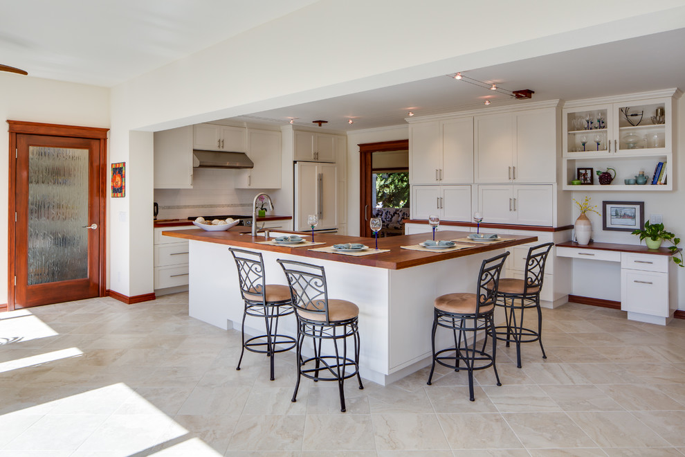 This is an example of a mid-sized contemporary eat-in kitchen in San Diego with an undermount sink, shaker cabinets, white cabinets, wood benchtops, white splashback, subway tile splashback, stainless steel appliances, porcelain floors and with island.