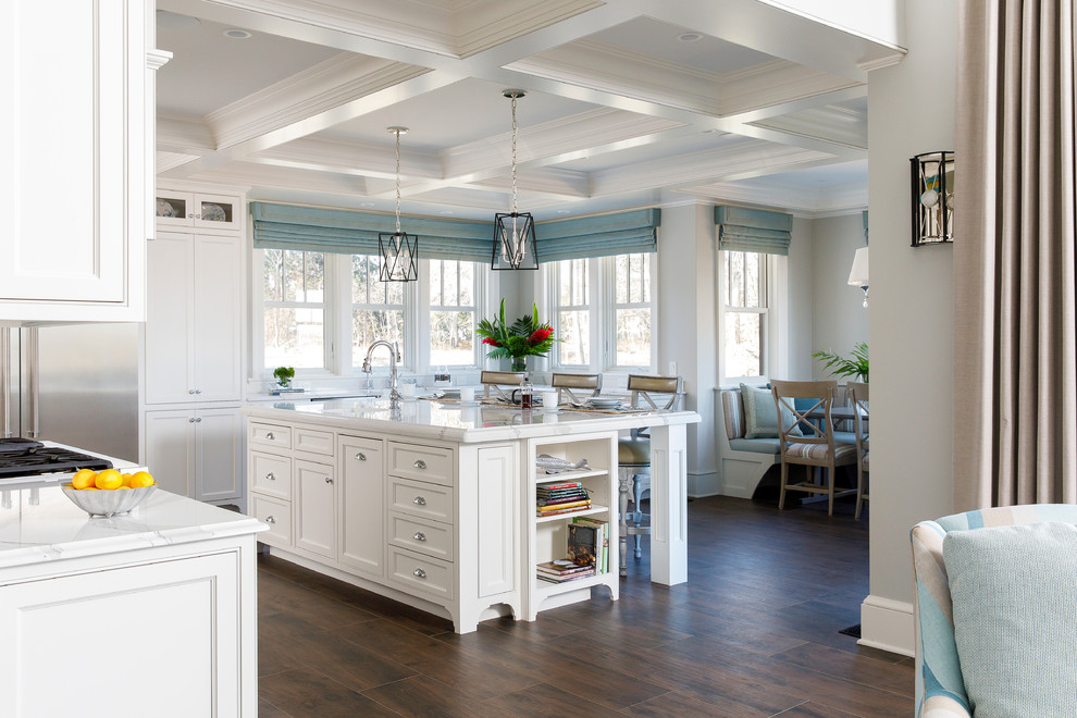 Inspiration for a beach style l-shaped open plan kitchen in Providence with an undermount sink, recessed-panel cabinets, white cabinets, stainless steel appliances, with island, brown floor and white benchtop.
