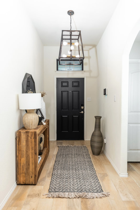 ダラスにある低価格の広いカントリー風のおしゃれな玄関ロビー (白い壁、トラバーチンの床、黒いドア、ベージュの床) の写真