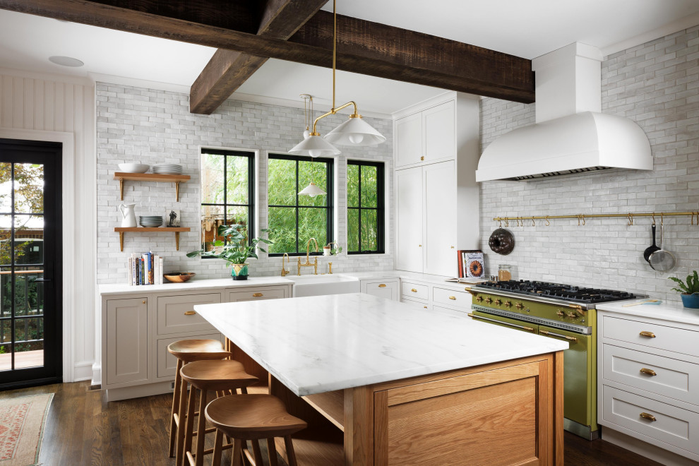 Design ideas for a large transitional l-shaped eat-in kitchen in DC Metro with a farmhouse sink, shaker cabinets, white cabinets, grey splashback, subway tile splashback, coloured appliances, dark hardwood floors, with island, brown floor, white benchtop and exposed beam.