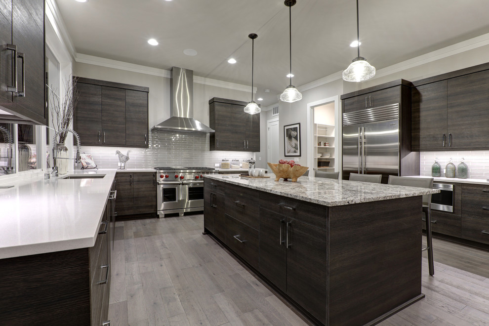 Inspiration for a large modern u-shaped eat-in kitchen in Jacksonville with an undermount sink, stainless steel appliances, with island, flat-panel cabinets, dark wood cabinets, quartzite benchtops, grey splashback, subway tile splashback, porcelain floors, grey floor and multi-coloured benchtop.
