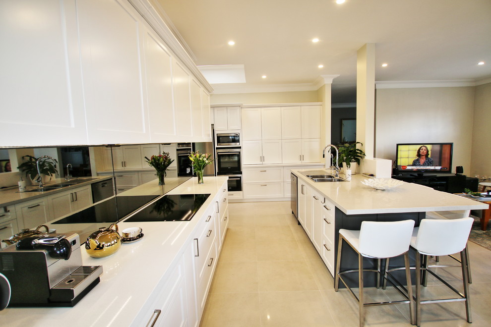 Design ideas for a large transitional l-shaped eat-in kitchen in Sydney with a drop-in sink, shaker cabinets, white cabinets, quartz benchtops, grey splashback, glass sheet splashback, stainless steel appliances, ceramic floors and with island.