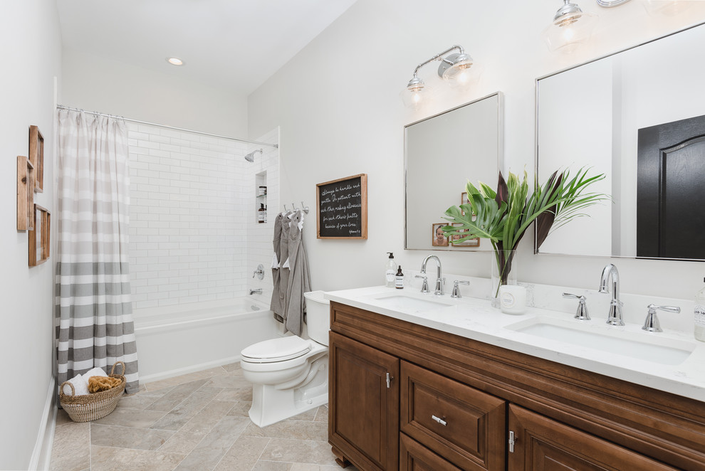 Design ideas for a traditional 3/4 bathroom in Charlotte with raised-panel cabinets, medium wood cabinets, an alcove tub, a shower/bathtub combo, a two-piece toilet, white tile, subway tile, beige walls, an undermount sink, beige floor, a shower curtain and white benchtops.