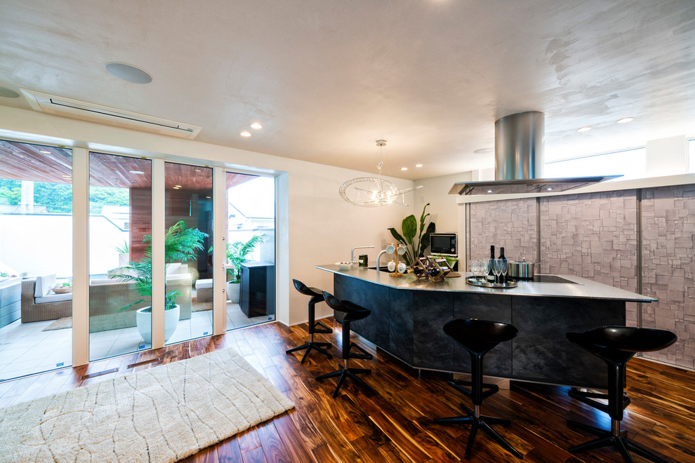 Moderne Hausbar in U-Form mit Bartheke, Edelstahl-Arbeitsplatte, gebeiztem Holzboden und braunem Boden in Sonstige