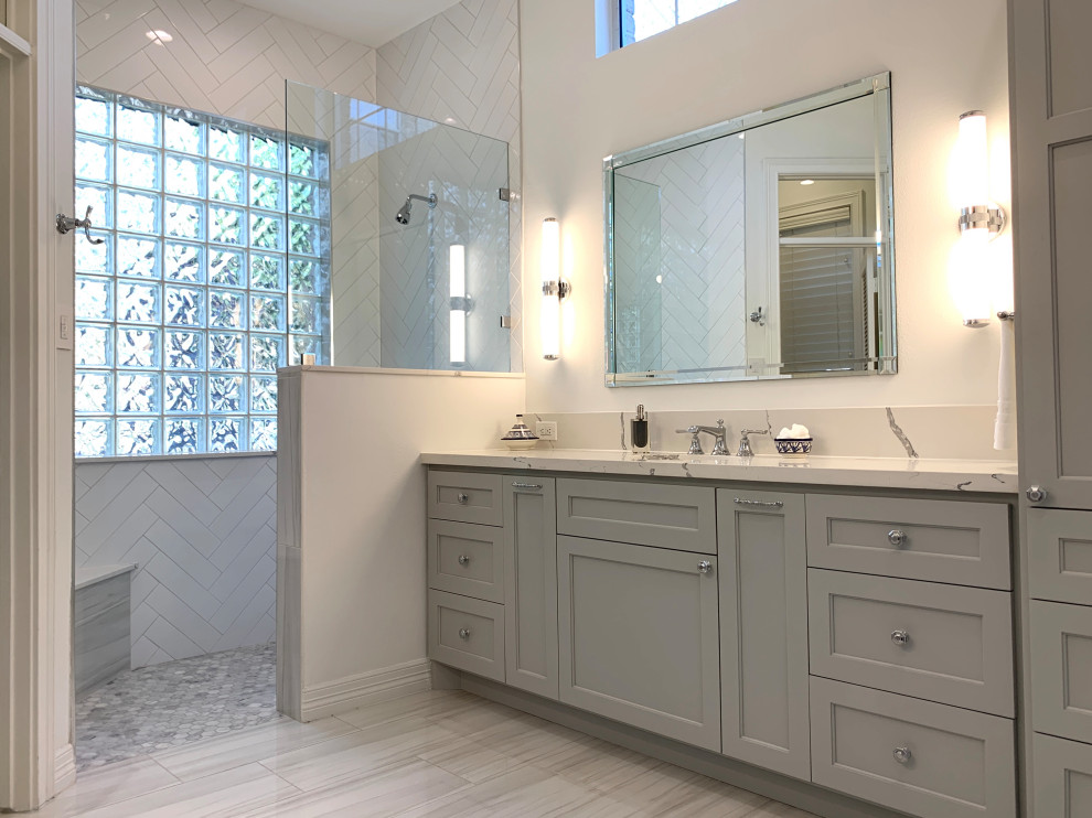 Пример оригинального дизайна: главная ванная комната в стиле неоклассика (современная классика) с фасадами в стиле шейкер, серыми фасадами, душем без бортиков, раздельным унитазом, белой плиткой, керамической плиткой, белыми стенами, полом из керамогранита, врезной раковиной, столешницей из искусственного кварца, серым полом, открытым душем, белой столешницей, нишей, тумбой под две раковины и встроенной тумбой