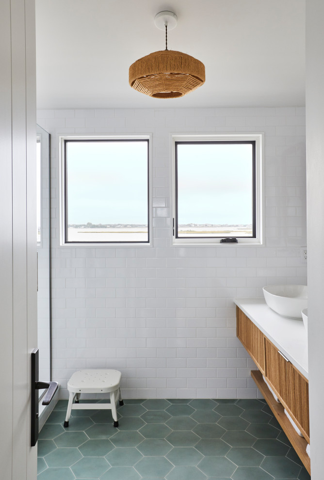 Design ideas for a beach style bathroom in New York with white tile, subway tile, green floor, a hinged shower door and a double vanity.