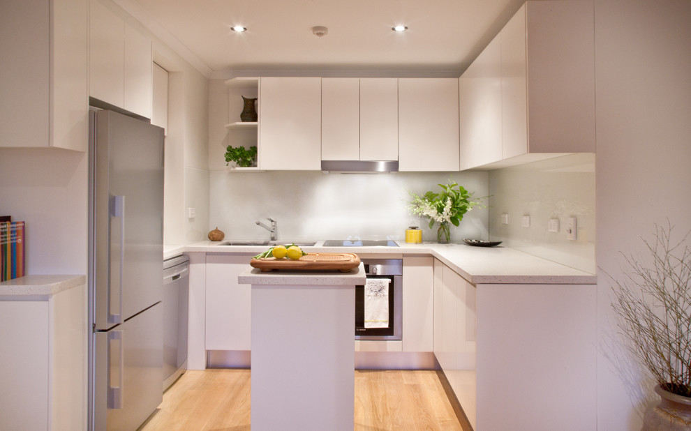 Design ideas for a small contemporary u-shaped kitchen/diner in Sydney with a double-bowl sink, white cabinets, wood worktops, glass sheet splashback and an island.