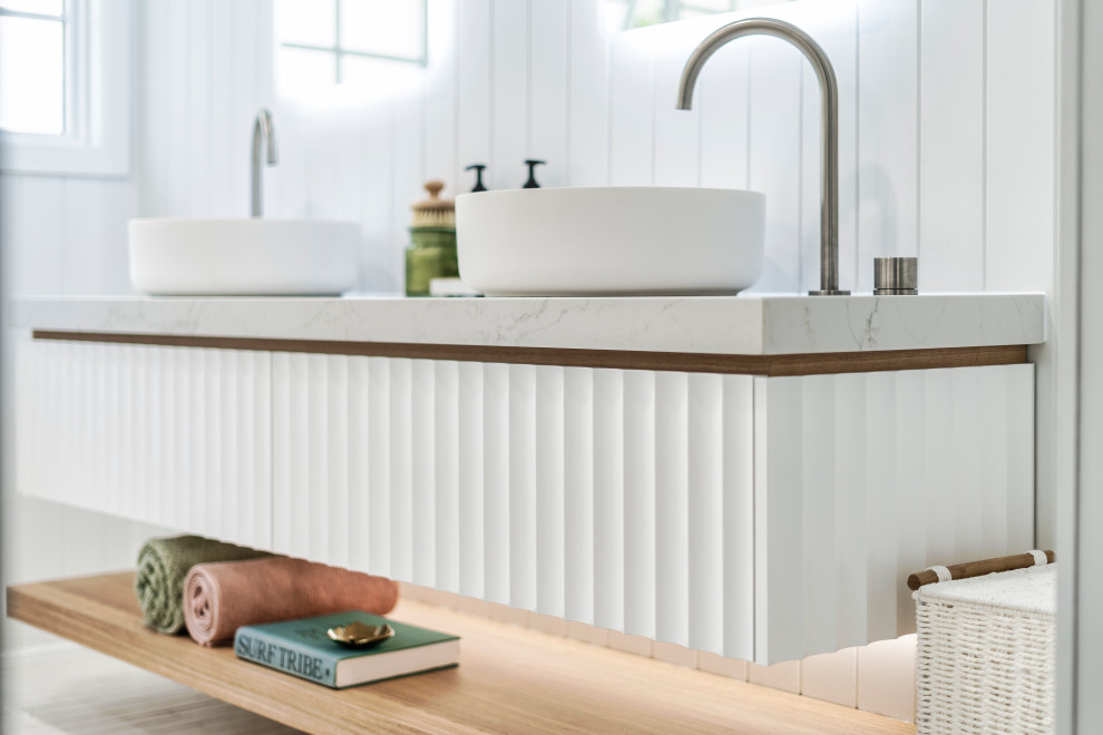 Inspiration for a mid-sized mediterranean kids bathroom in Gold Coast - Tweed with furniture-like cabinets, white cabinets, a freestanding tub, an open shower, a one-piece toilet, white tile, porcelain tile, white walls, porcelain floors, a vessel sink, engineered quartz benchtops, white floor, an open shower, white benchtops, an enclosed toilet, a floating vanity and planked wall panelling.