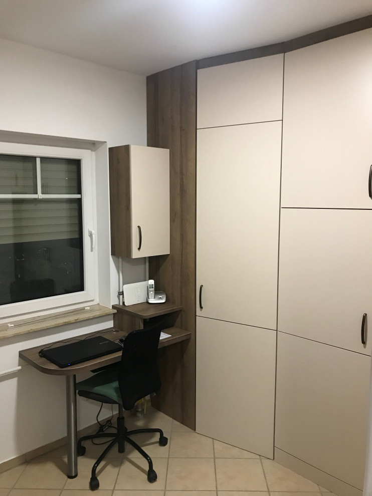 Multifunktionaler, Mittelgroßer Moderner Hauswirtschaftsraum mit Ausgussbecken, flächenbündigen Schrankfronten, beigen Schränken, Laminat-Arbeitsplatte, weißer Wandfarbe, Keramikboden, Waschmaschine und Trockner gestapelt, beigem Boden und brauner Arbeitsplatte in Berlin