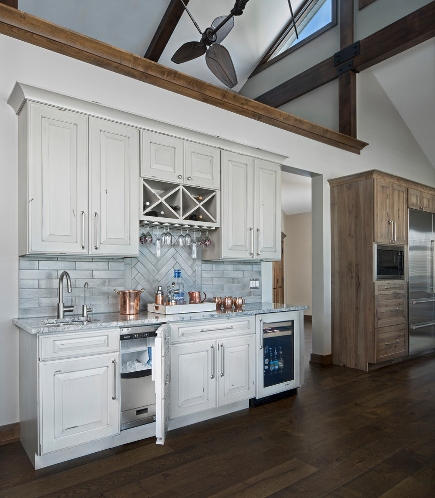 Kitchen - rustic medium tone wood floor and brown floor kitchen idea with raised-panel cabinets, distressed cabinets, quartz countertops, gray backsplash, ceramic backsplash and stainless steel appliances