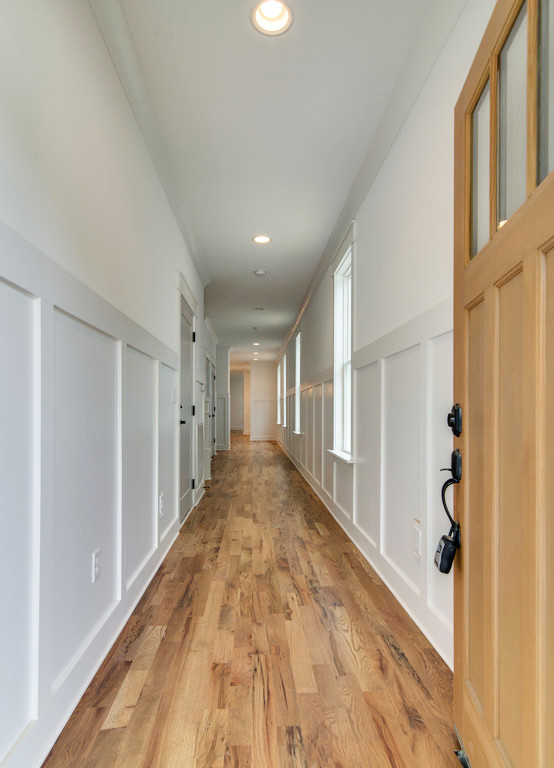 Design ideas for a mid-sized arts and crafts hallway in Nashville with white walls, light hardwood floors and beige floor.