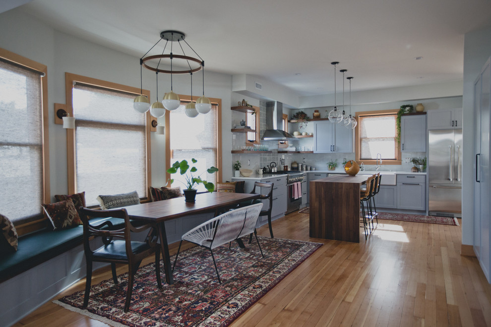 Design ideas for a mid-sized transitional kitchen/dining combo in Portland with grey walls, light hardwood floors and no fireplace.