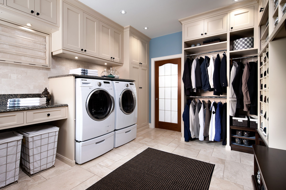 Photo of a large traditional utility room in Toronto with beige cabinets, beige walls and a side-by-side washer and dryer.