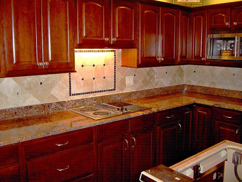 Inspiration for a transitional kitchen remodel in Austin with medium tone wood cabinets, beige backsplash, stainless steel appliances and an island