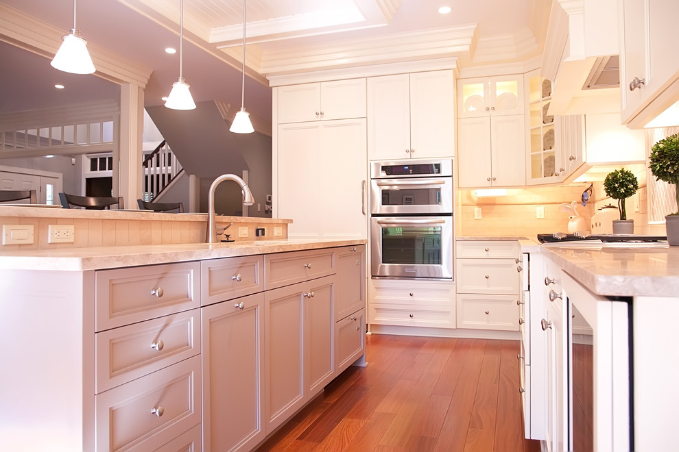 Inspiration for a traditional l-shaped eat-in kitchen in Philadelphia with an undermount sink, recessed-panel cabinets, white cabinets, granite benchtops, white splashback, subway tile splashback and stainless steel appliances.
