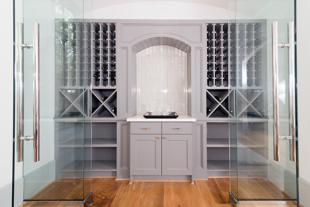 Large traditional wine cellar in Houston with light hardwood floors and storage racks.