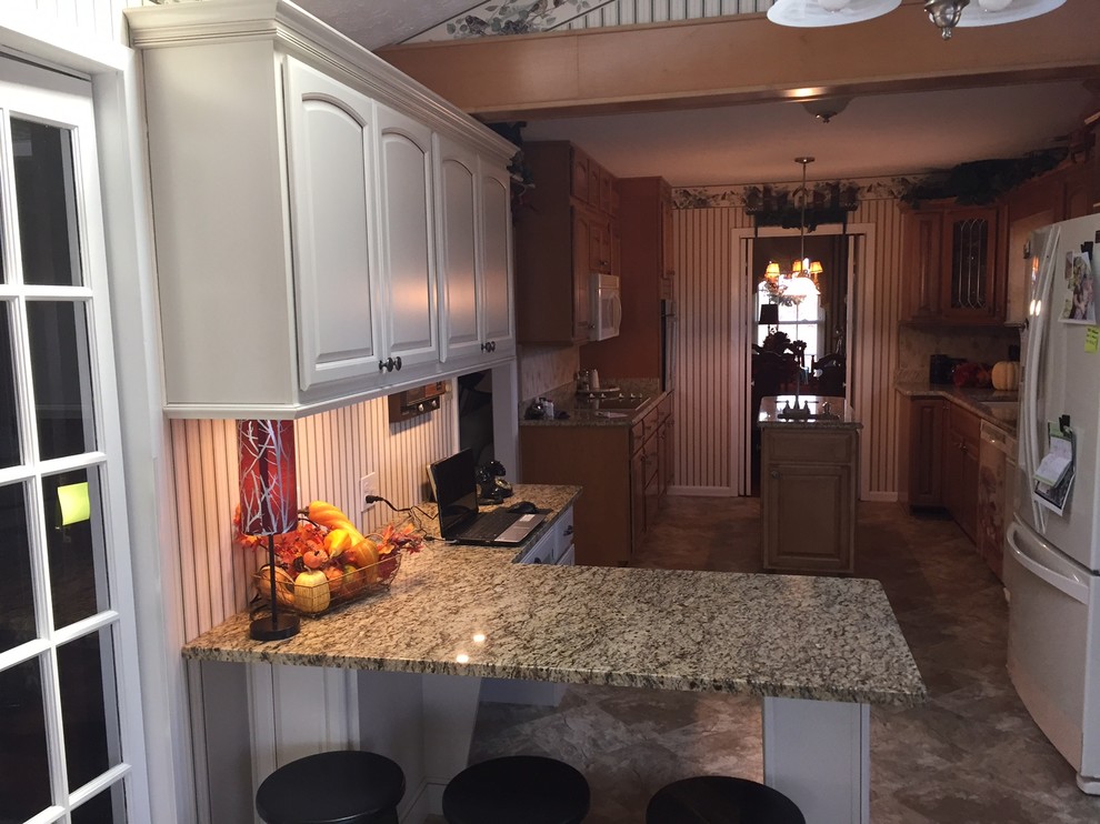Small transitional l-shaped eat-in kitchen photo with raised-panel cabinets, beige cabinets, granite countertops and a peninsula