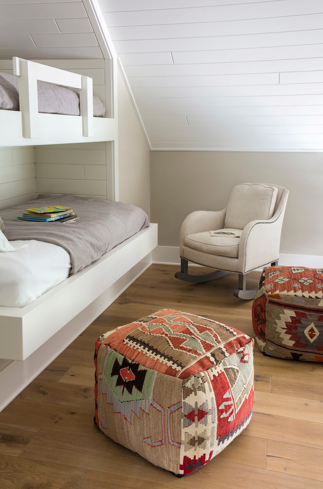 This is an example of a transitional gender-neutral kids' bedroom in Other with grey walls and light hardwood floors.