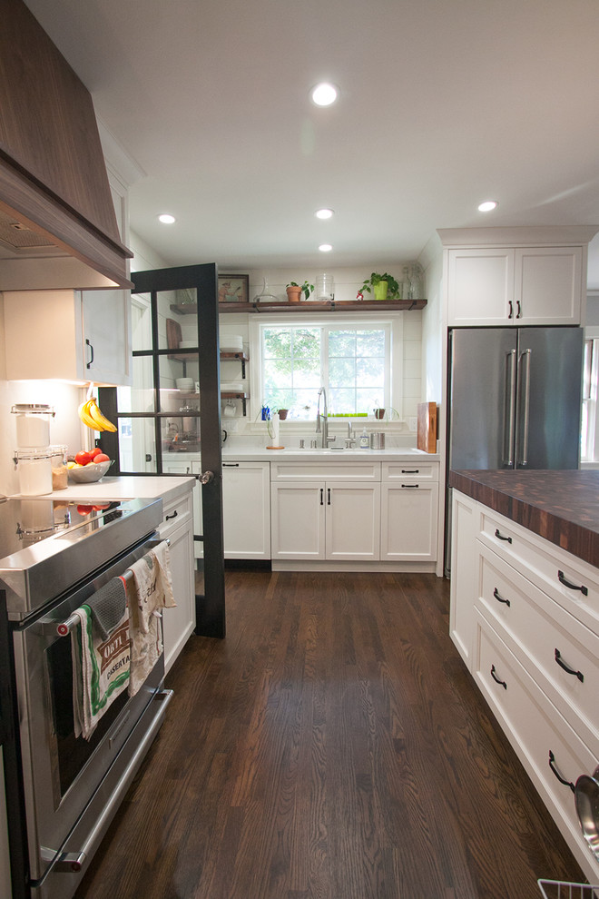 Photo of a mid-sized arts and crafts u-shaped eat-in kitchen in San Francisco with an undermount sink, recessed-panel cabinets, white cabinets, quartz benchtops, white splashback, stone slab splashback, stainless steel appliances, medium hardwood floors, with island and brown floor.