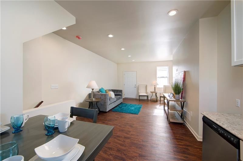 Inspiration for a small transitional galley brown floor eat-in kitchen remodel with a single-bowl sink, shaker cabinets, white cabinets, laminate countertops, stainless steel appliances and no island
