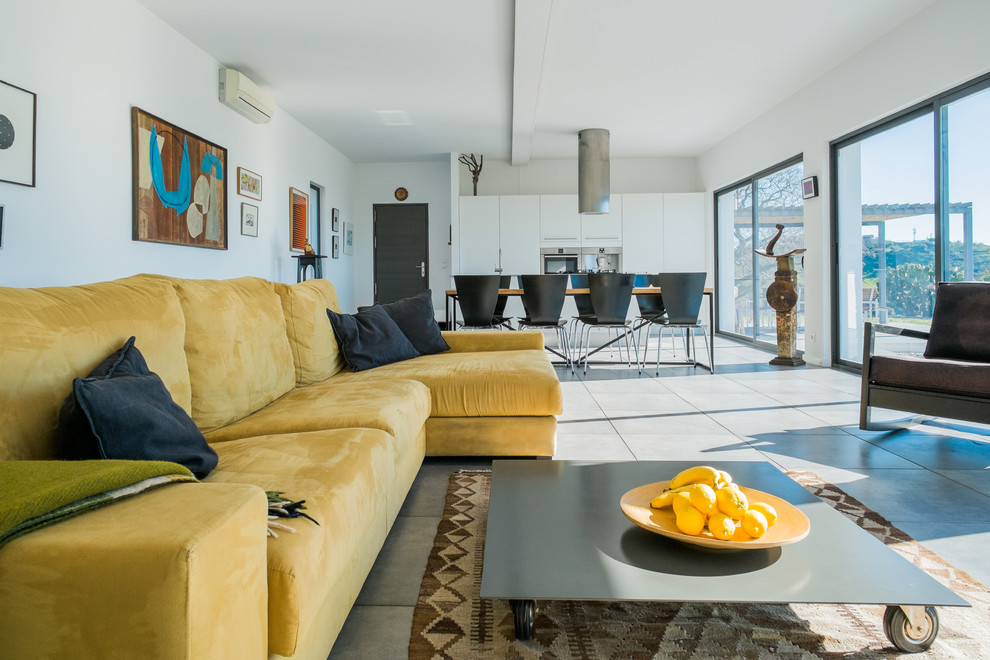 This is an example of a large contemporary formal open concept living room in Malaga with white walls, concrete floors, no fireplace and no tv.
