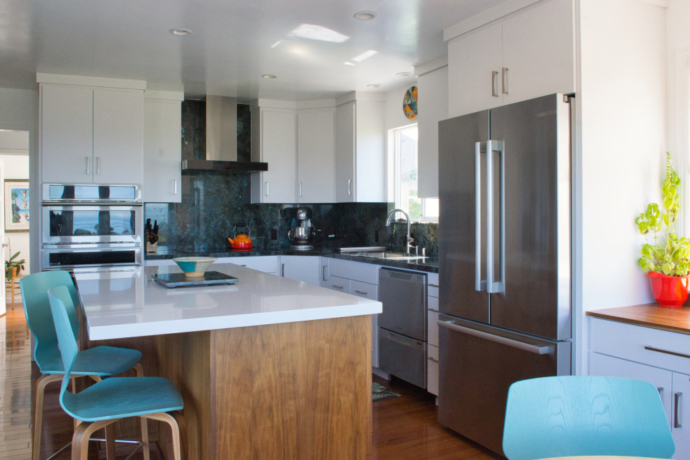 This is an example of a mid-sized modern l-shaped separate kitchen in San Francisco with an undermount sink, flat-panel cabinets, dark wood cabinets, granite benchtops, blue splashback, granite splashback, stainless steel appliances, medium hardwood floors, with island, brown floor and blue benchtop.