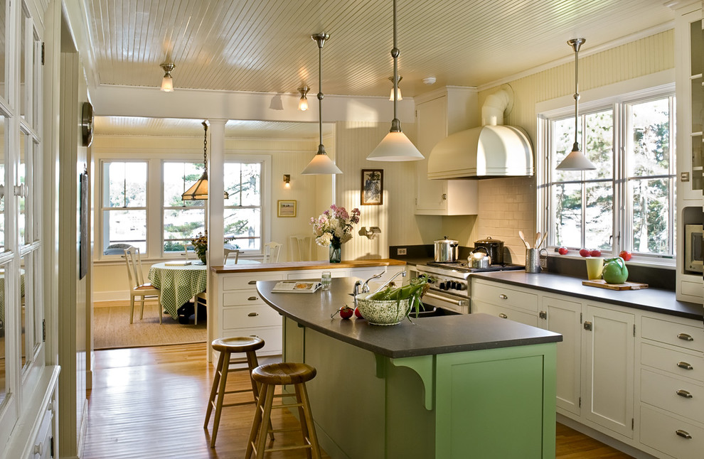 Design ideas for a beach style l-shaped separate kitchen in Portland Maine with subway tile splashback, stainless steel appliances, shaker cabinets, white cabinets, granite benchtops and white splashback.
