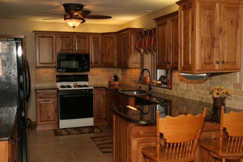 Transitional u-shaped medium tone wood floor kitchen pantry photo in Chicago with raised-panel cabinets, medium tone wood cabinets and granite countertops