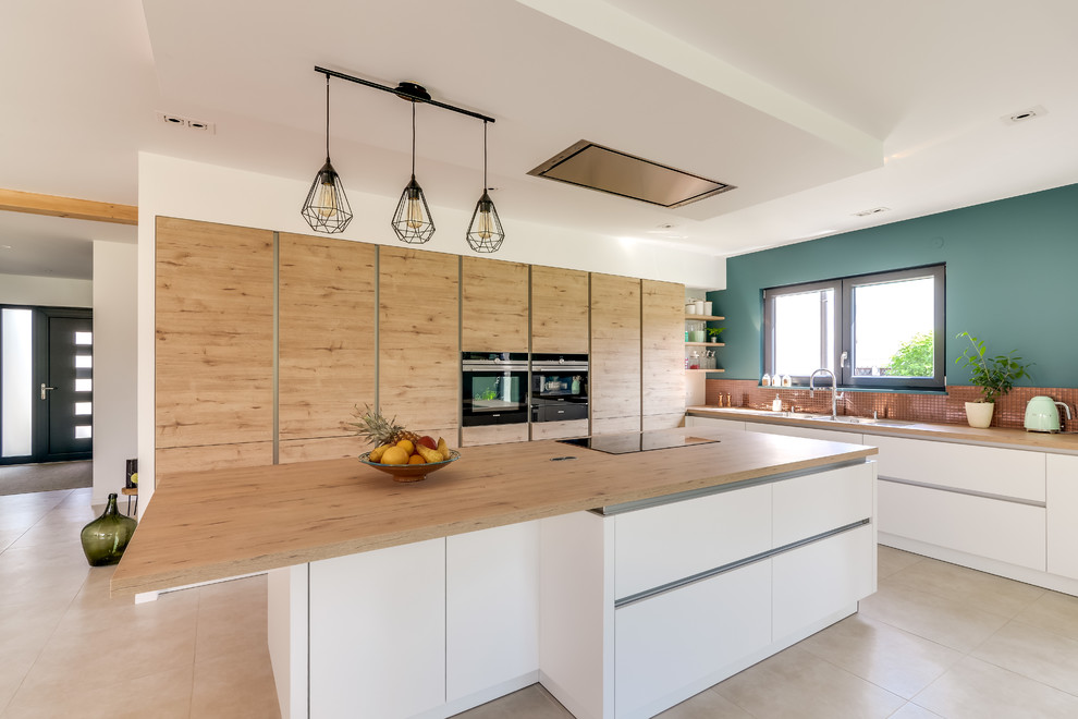 Inspiration for a contemporary l-shaped open plan kitchen in Strasbourg with a double-bowl sink, light wood cabinets, laminate benchtops, mosaic tile splashback, stainless steel appliances, concrete floors, with island and beige floor.