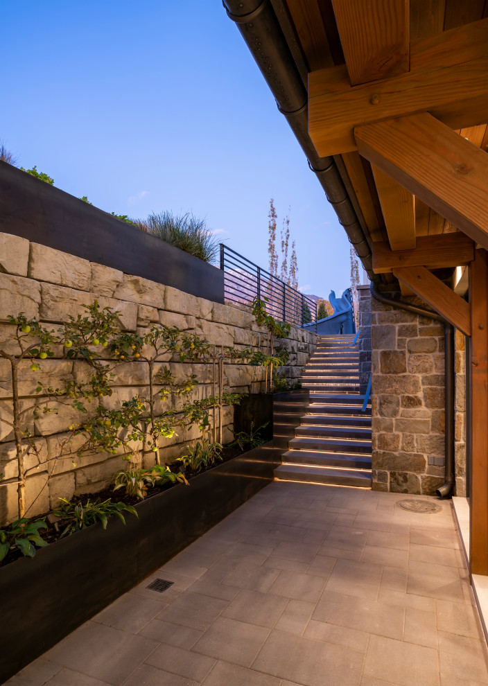This is an example of a large country courtyard patio in Salt Lake City with a vertical garden, concrete pavers and a roof extension.
