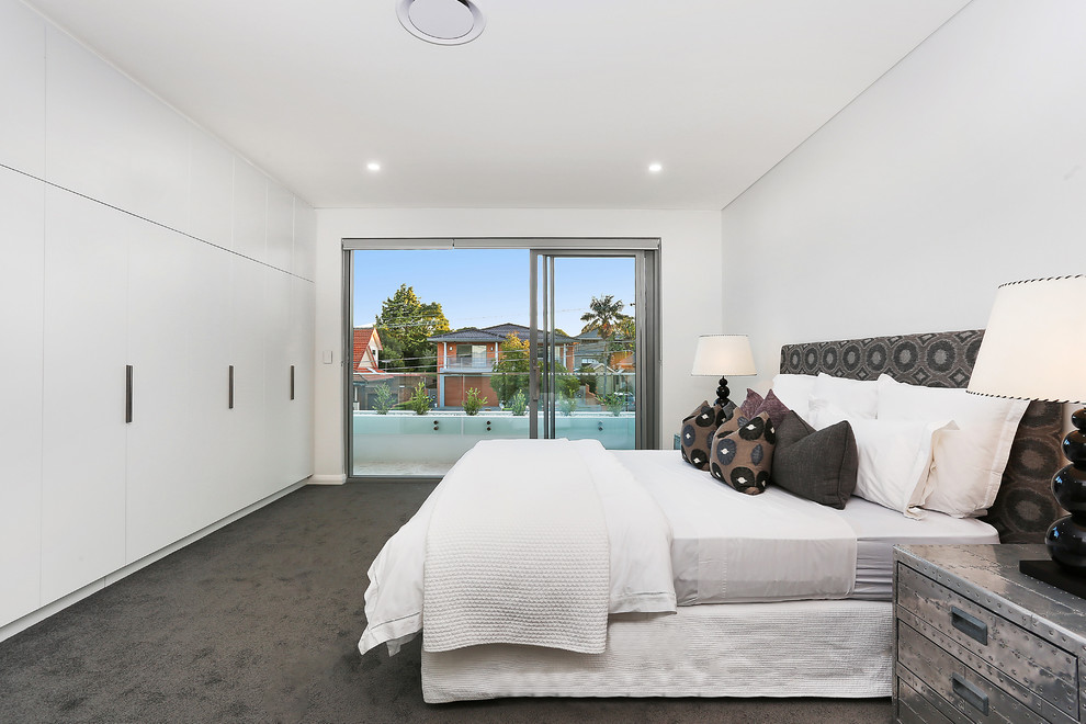 Photo of a contemporary master bedroom in Sydney with white walls, carpet and grey floor.