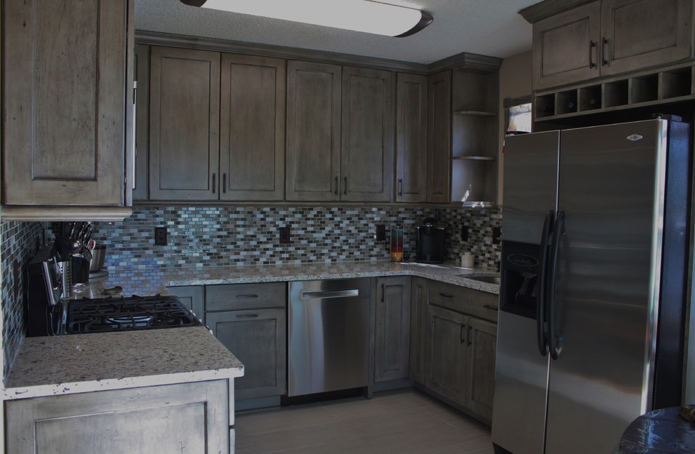 Example of a small transitional u-shaped ceramic tile kitchen design in Charlotte with no island, flat-panel cabinets, distressed cabinets, granite countertops, gray backsplash, mosaic tile backsplash, stainless steel appliances and an undermount sink