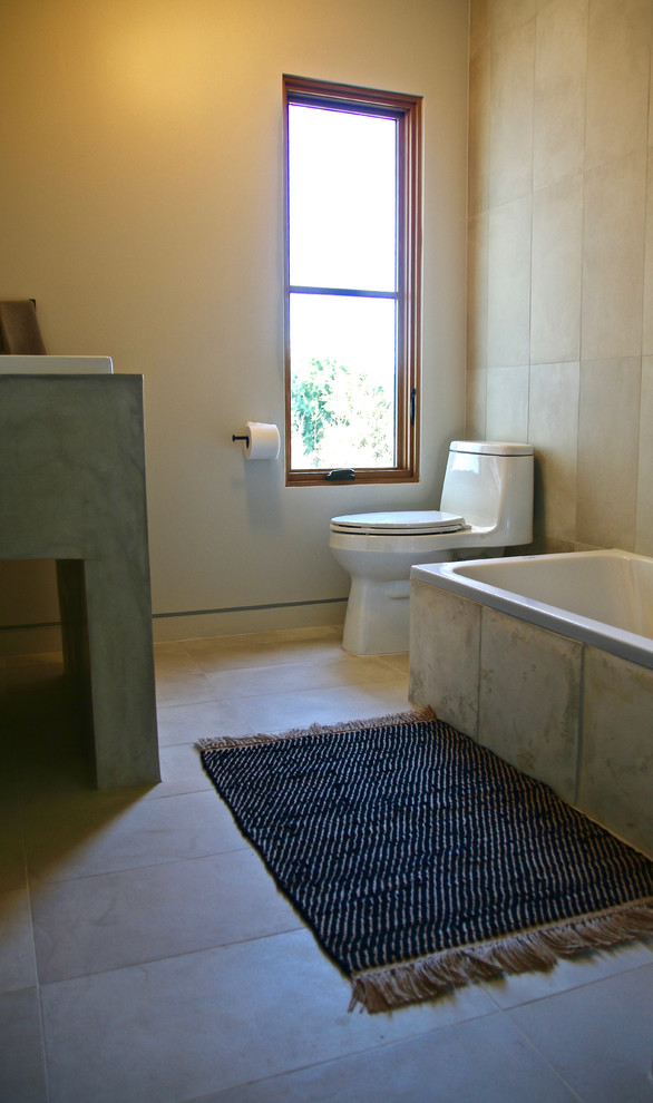 Inspiration for a large contemporary kids bathroom in Los Angeles with a drop-in tub, a one-piece toilet, gray tile, porcelain tile, white walls, porcelain floors, an undermount sink and concrete benchtops.