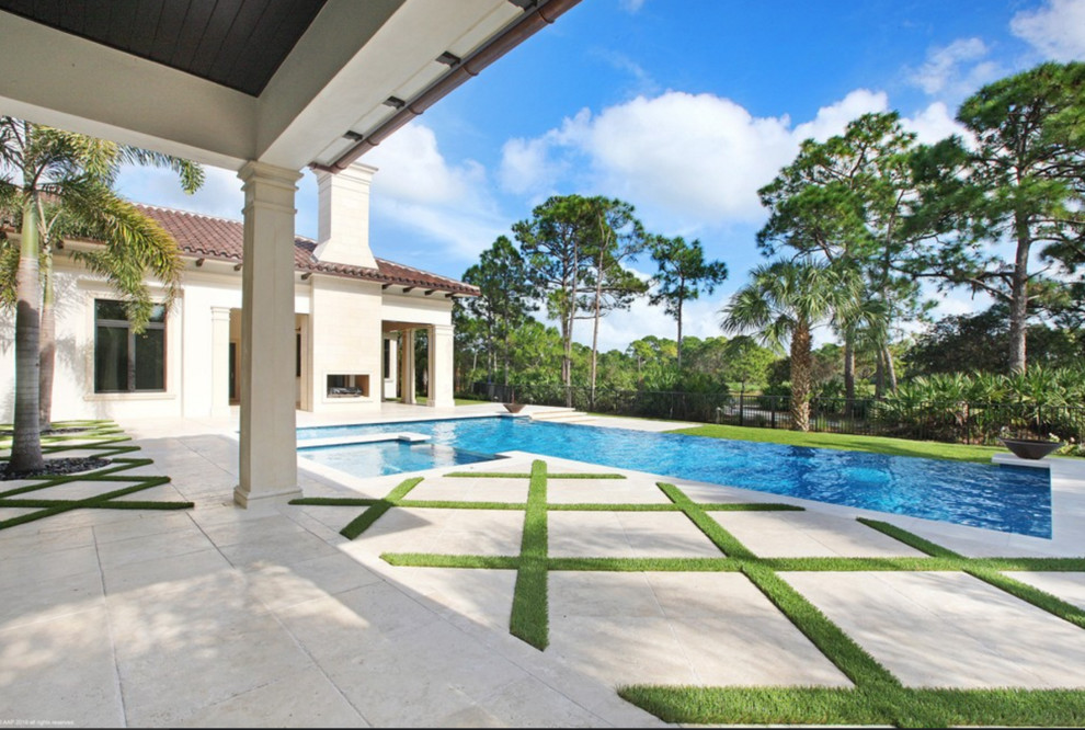 This is an example of a large mediterranean backyard rectangular infinity pool in Miami with a hot tub and concrete pavers.