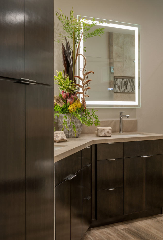 Inspiration for a mid-sized contemporary master bathroom in San Francisco with flat-panel cabinets, dark wood cabinets, a one-piece toilet, beige tile, brown tile, porcelain tile, grey walls, porcelain floors, an undermount sink and limestone benchtops.