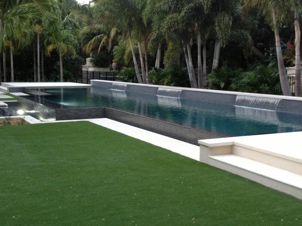 Example of a large backyard custom-shaped natural pool fountain design in Miami