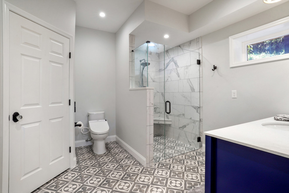 Walk-in shower - mid-sized transitional master multicolored tile and porcelain tile porcelain tile, gray floor and single-sink walk-in shower idea in Atlanta with blue cabinets, quartz countertops, a hinged shower door, white countertops and a freestanding vanity