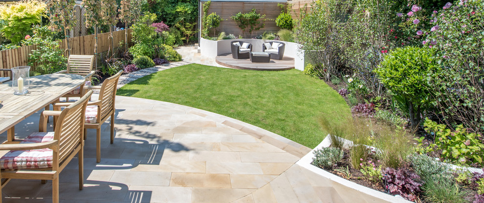 Inspiration for a mid-sized contemporary backyard full sun garden for spring in London with natural stone pavers.