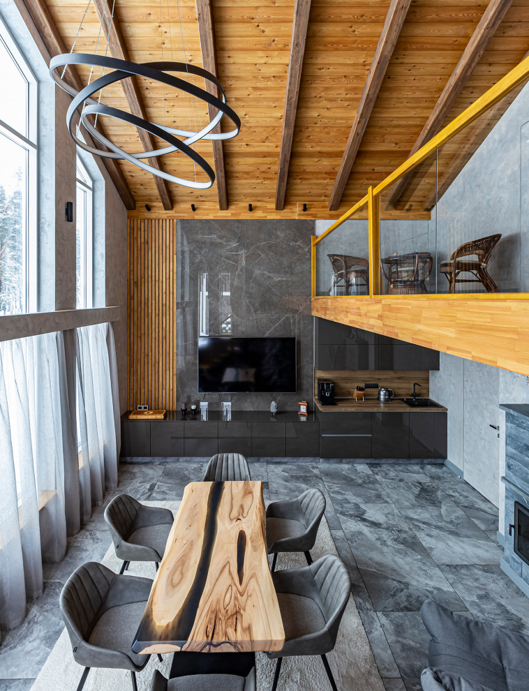 This is an example of an expansive contemporary open plan living room in Saint Petersburg with grey walls, porcelain flooring, a standard fireplace, a stone fireplace surround, a wall mounted tv, grey floors and panelled walls.