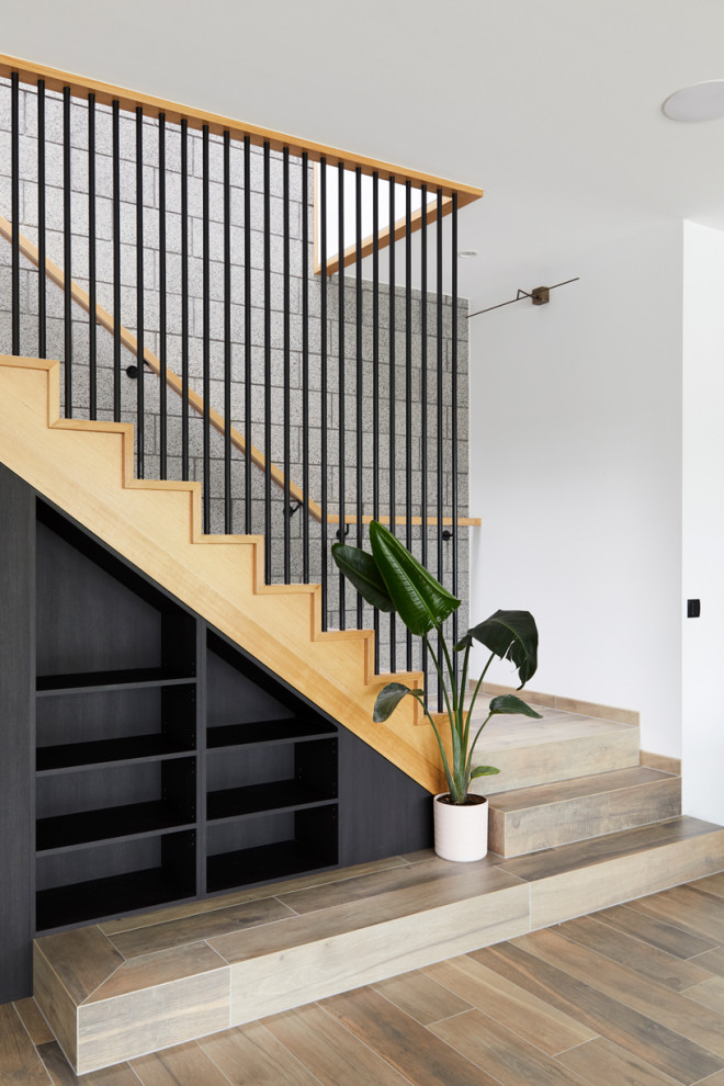 Idées déco pour un escalier contemporain en L de taille moyenne avec des marches en moquette, des contremarches en moquette, un garde-corps en bois et un mur en parement de brique.
