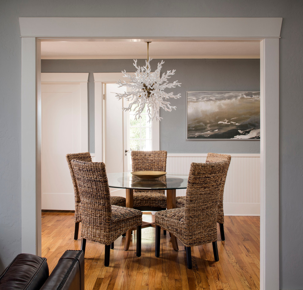 This is an example of a small beach style separate dining room in San Diego with grey walls and light hardwood floors.