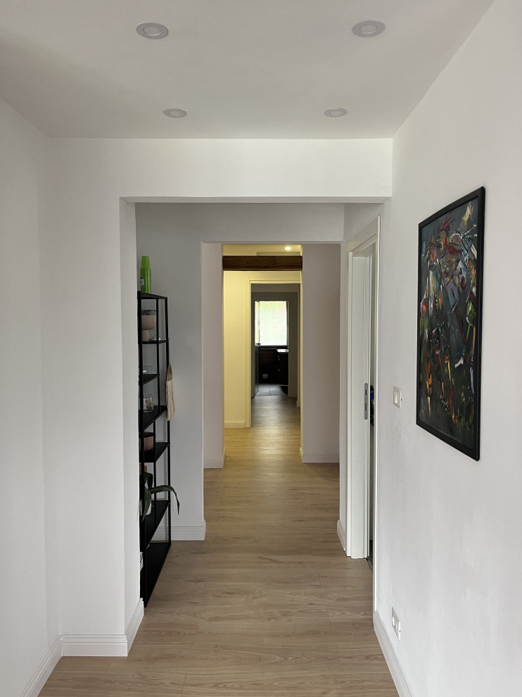 Ispirazione per un ingresso o corridoio moderno di medie dimensioni con pareti bianche, pavimento in laminato e soffitto ribassato