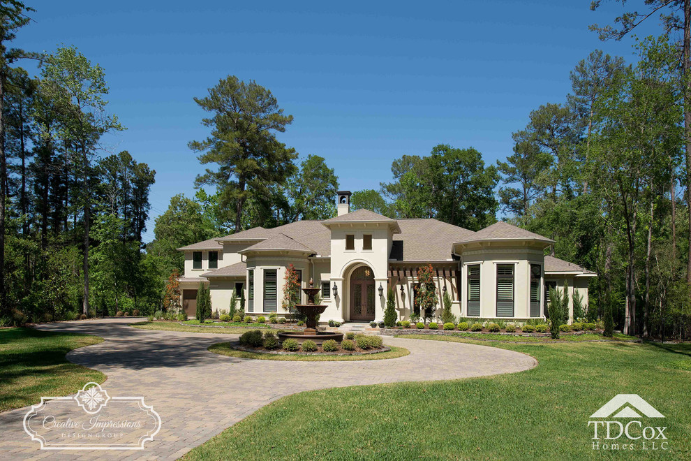 Large transitional beige two-story stucco gable roof idea in Houston with a shingle roof